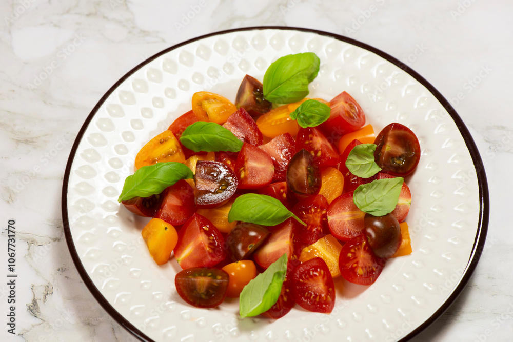 Salad with halves of red and yellow tomatoes cherry with basil Salad with halves of red and yellow tomatoes cherry with basil