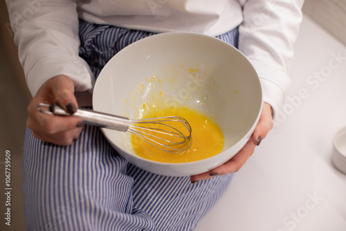 Woman at home in her kitchen cooking, woman hands, culinary blog, step-by-step recipe for cooking a dish, breakfast , recipe, plate and whisk for preparing breakfast