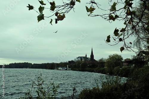 church spire on the shore of a lake in rainy weather