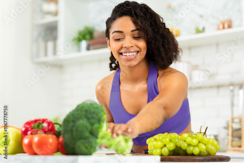 Lose Weight and Improve Health. Smiling black girl cooking at home in modern kitchen, copy space