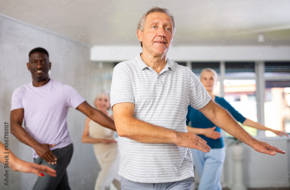 Obraz premium Dynamic mature attendees of dancing courses training Hip-hop dance poses in dancehall