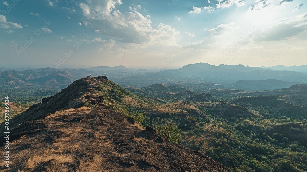Obraz premium A panoramic view of a mountain range with a blue sky and white clouds.
