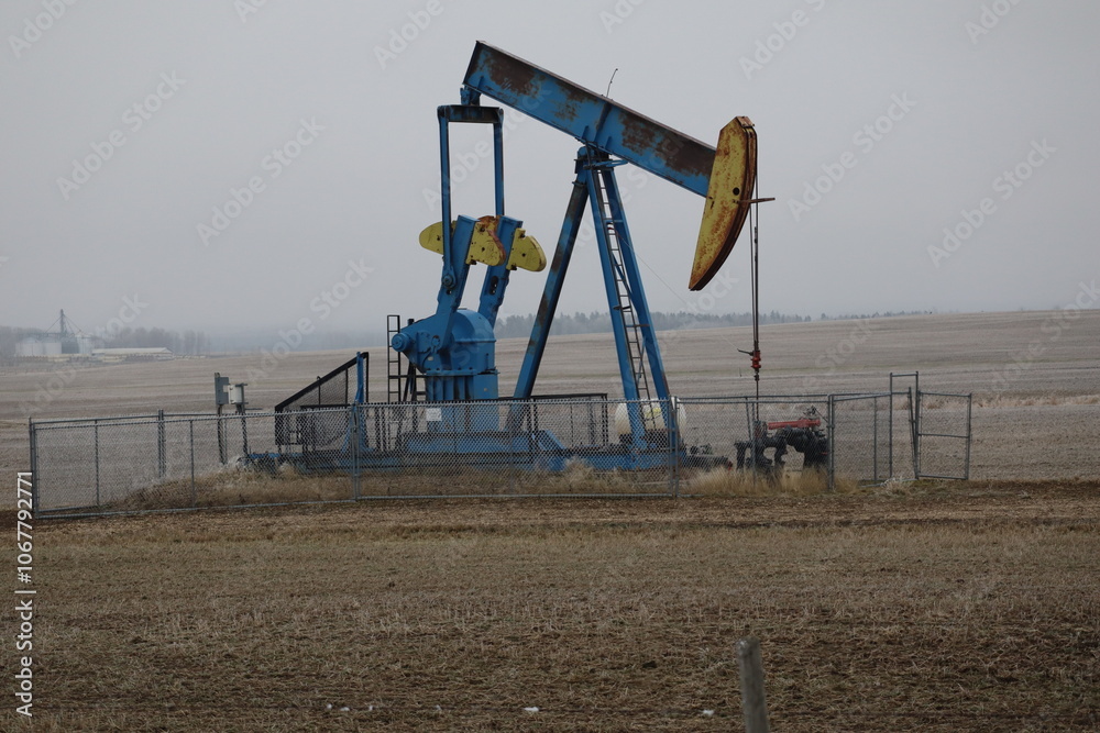 A single pumpjack, or beam pump, pumping oil on the prairies. A single pumpjack, or beam pump, pumping oil on the prairies.