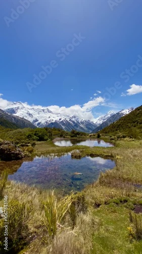 Hill top view of Aoraki Mount Cook and blue sky with clouds reflecting in water at Red Tarns, Mount Cook National Park, New Zealand. Reflection in the lake. Landscape with lake and mountains