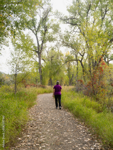 Active Senior Woman Walking in the Woods Photographed from Behind