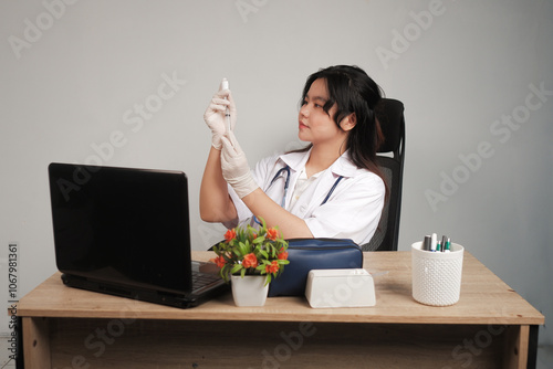 Young asian doctor woman holding syringe and vaccine relaxed with serious expression on facc photo