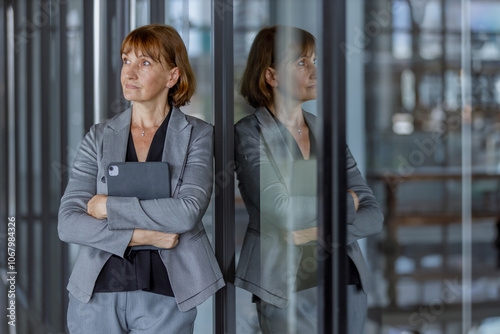 Wallpaper Mural Portrait of middle aged woman company HR holding digital tablet wearing black suit standing at modern office. Marketing department manager and looking after partner customers Torontodigital.ca