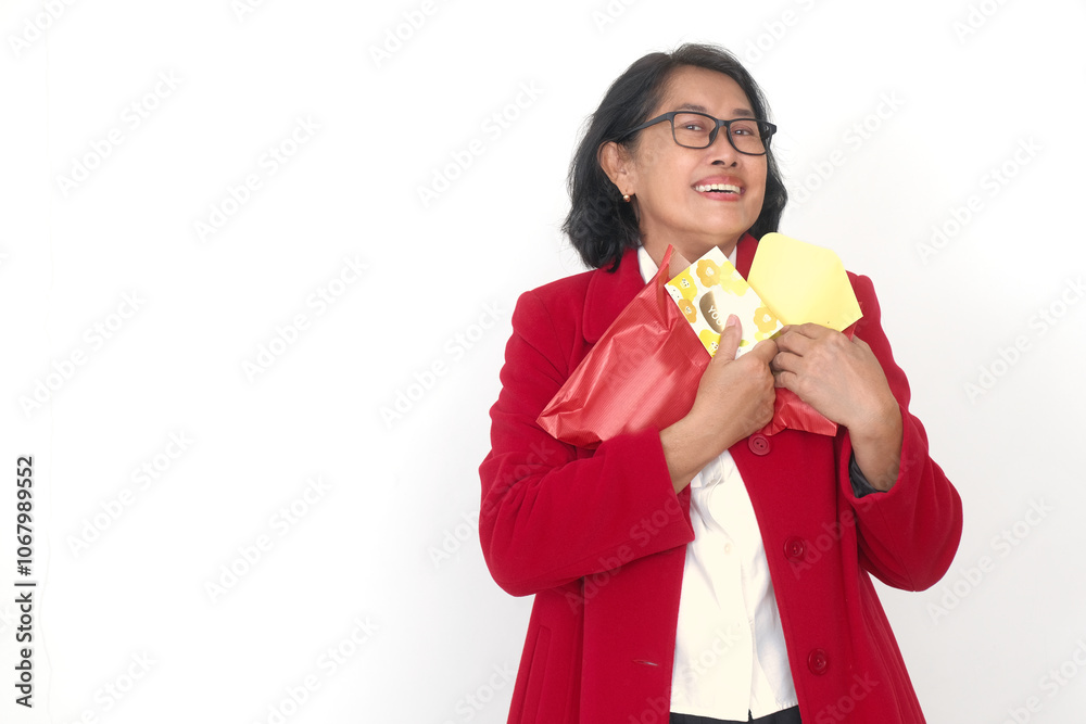 Adult Asian woman wearing red Christmas suit holding some presents in her hands Adult Asian woman wearing red Christmas suit holding some presents in her hands