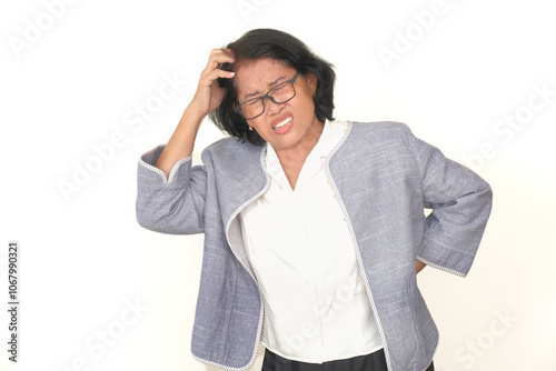 Asian businesswoman standing alone in her office scratching her head, under a lot of stress