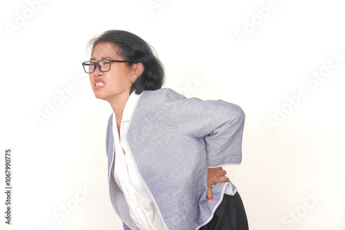 Asian middle-aged woman standing alone feeling painful, suffering from severe backache photo