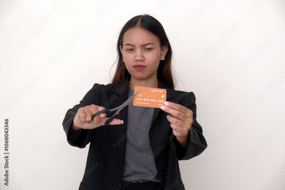 Business woman standing and holding a pair of scissors to cut credit card in her hand Business woman standing and holding a pair of scissors to cut credit card in her hand