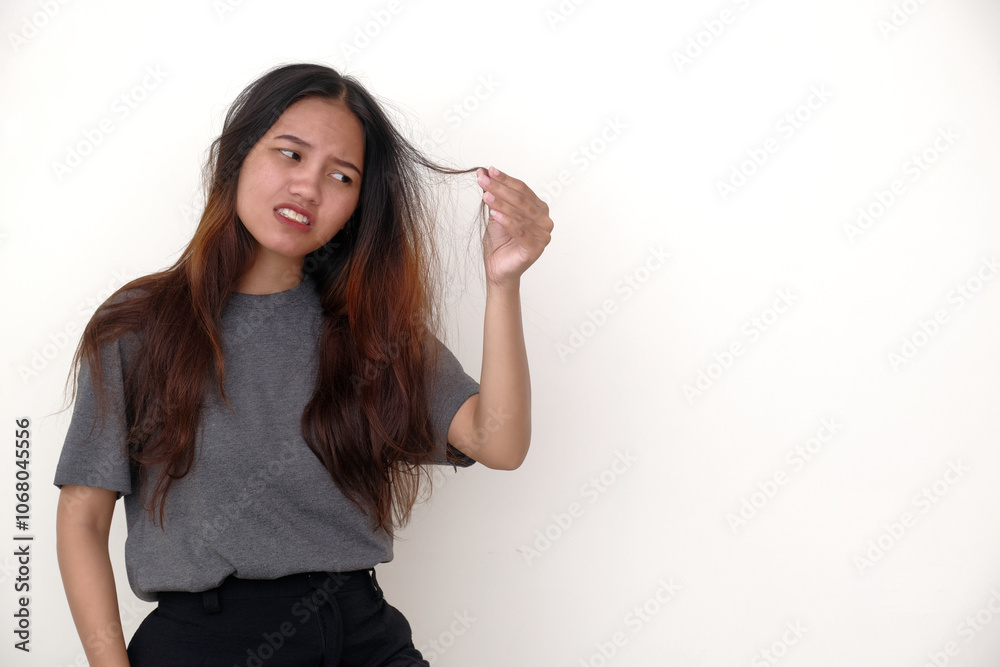 Facial expression of Asian woman looking unhappy with her hair full of dandruff Facial expression of Asian woman looking unhappy with her hair full of dandruff