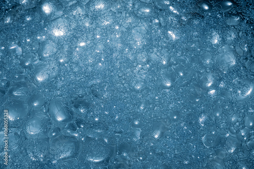 A close-up view reveals a multitude of blue bubbles clustered together, reflecting diffused light, creating a captivating texture and pattern in this abstract display. photo