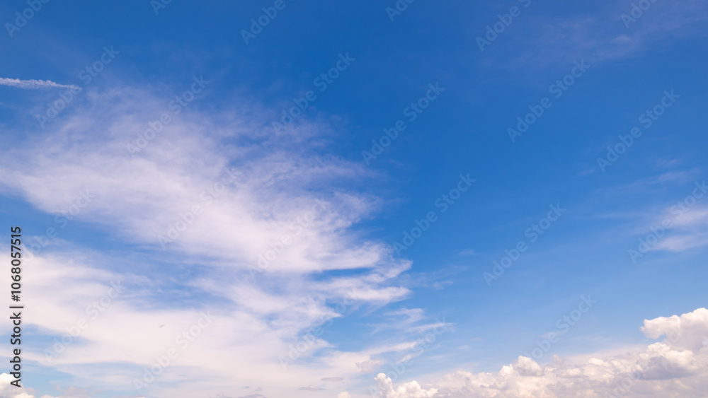 Obraz premium clear blue sky background,clouds with background, Blue sky background with tiny clouds. White fluffy clouds in the blue sky. Captivating stock photo featuring the mesmerizing beauty of the sky and cl