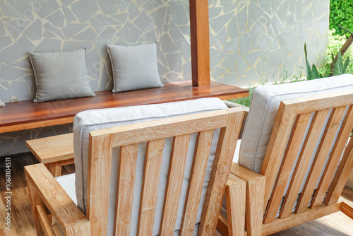 Wicker chair and wooden table in restaurant,Rattan chair in scandinavian interior of living room,Mediterranean minimal wall and green plant exterior architecturer,warm beige tones,copy space. photo