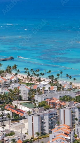 Vertical aerial view of Los Corales Bavaro beach. Residential buildings on the shore of the turquoise Caribbean sea. Apartments for Short-Term rent in Dominican Republic