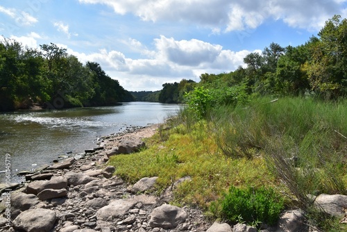 River bank with stones and greenery trees in McKinney Roughs Nature Park in Texas photo