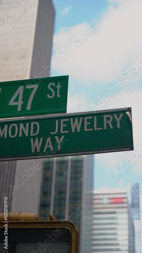 A street sign showing W 47th Street and Diamond Jewel Way in the bustling New York City, showcasing urban signage