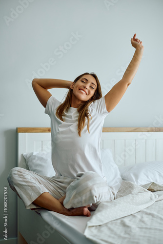 Happy woman waking up  in  morning in her bedroom.