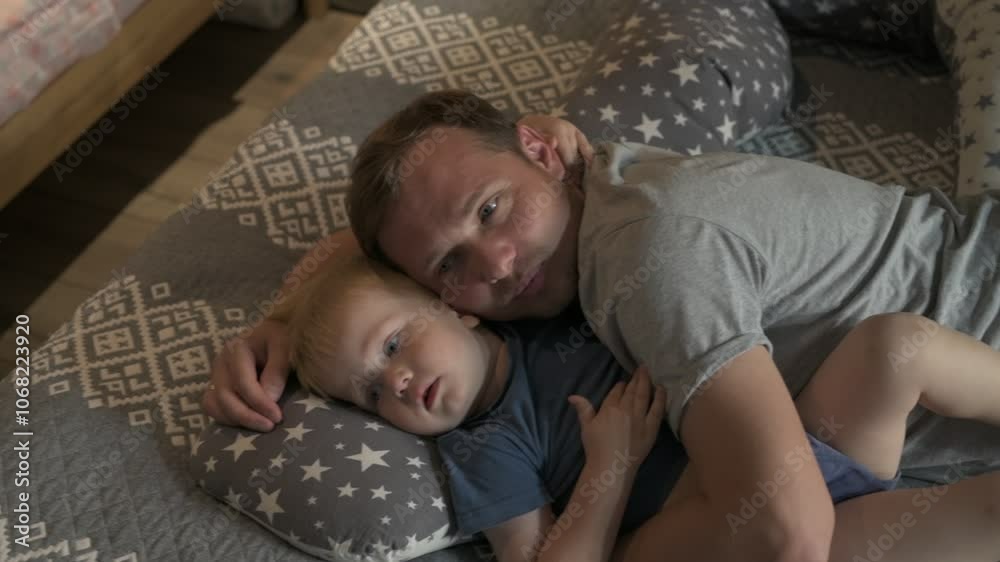 Happy family father and little son spending time together at home, playing games and watching cartoons Happy family father and little son spending time together at home, playing games and watching cartoons