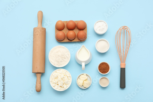 Different ingredients for preparing sweet cinnamon roll on blue background photo