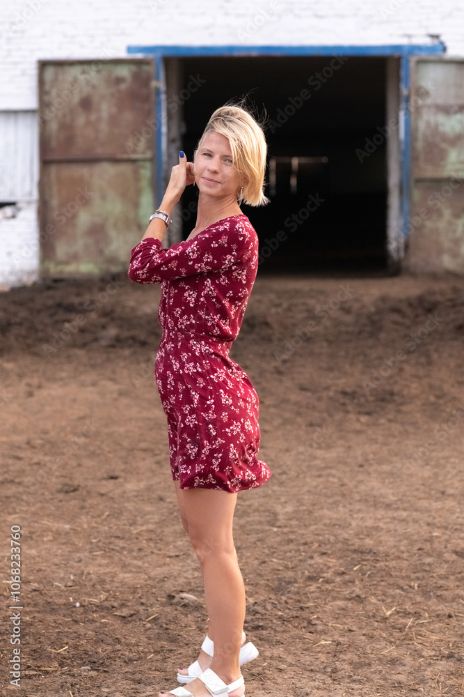 Portrait of a beautiful blonde girl in a red dress on a ranch. Portrait of a beautiful blonde girl in a red dress on a ranch.