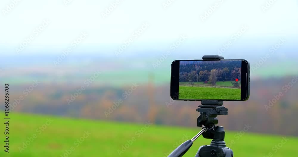 A smartphone on a tripod records sweeping vistas of an expansive countryside under a vast sky, illustrating the intersection of art and technology in scenic photography. A smartphone on a tripod records sweeping vistas of an expansive countryside under a vast sky, illustrating the intersection of art and technology in scenic photography.
