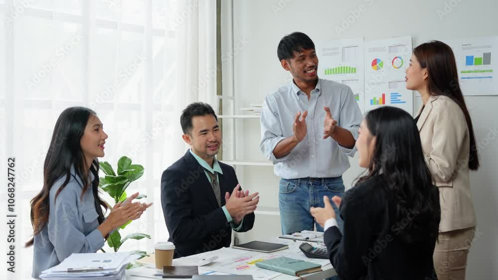 A team of office workers works, meets, discusses and is celebrating a financial business success. Show signs of joy, clapping, and cheerfulness in working together. Success concept.