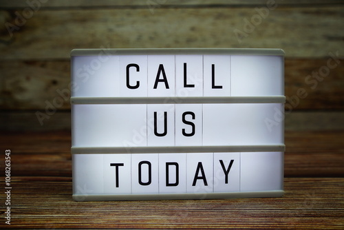 CALL US TODAY letterboard text on LED Lightbox on wooden background, Business and Communication concept background photo