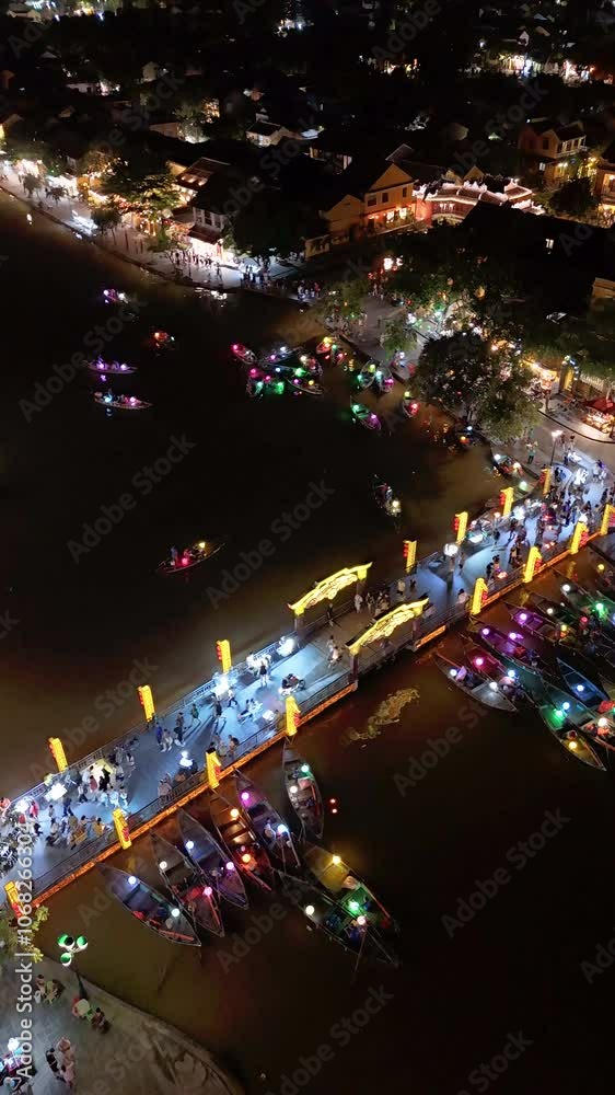Timelapse or time-lapse of Aerial view of Hoi An old town or Hoian ancient town in evening. Royalty high-quality free stock of Hoai river and boat tour night traffic. One of the most popular touristic