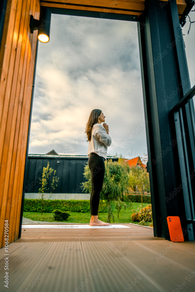 Young woman stands on nails on the terrace near the house early in the morning. Sadhu boards. Nail concept