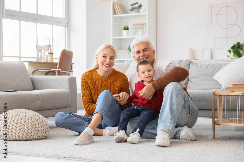 Cute little boy with happy grandparents sitting on floor at home Cute little boy with happy grandparents sitting on floor at home