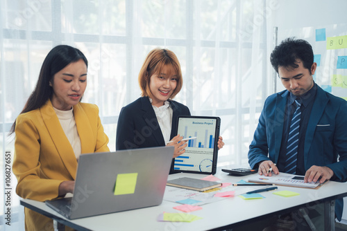 Business Professionals Collaborating: A diverse team of business professionals is gathered in a modern office, collaborating on a project. Their focus and dedication are evident as they work together.