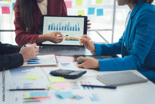 Business Data Analysis: A team of professionals collaborating around a table, analyzing data on a laptop screen. The image captures the essence of strategic decision-making, collaboration. photo