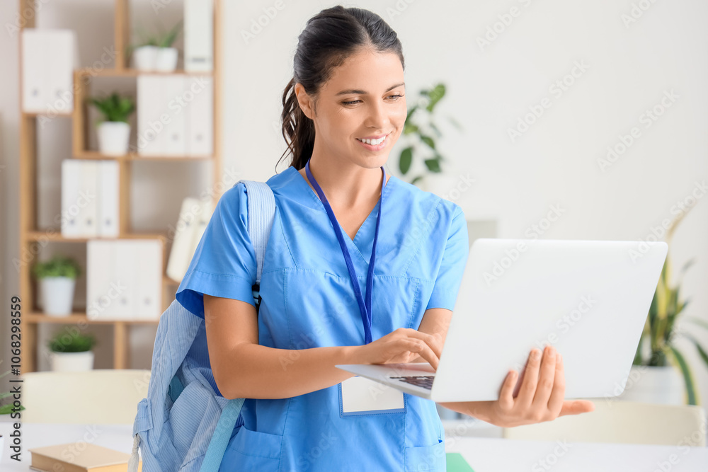 Young female medical student with laptop in clinic Young female medical student with laptop in clinic
