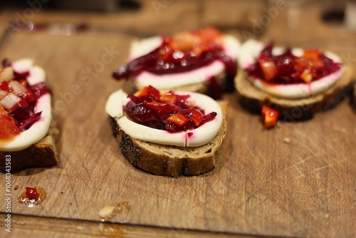 Delicious canaps featuring cream cheese and fresh fruit toppings on rustic bread photo