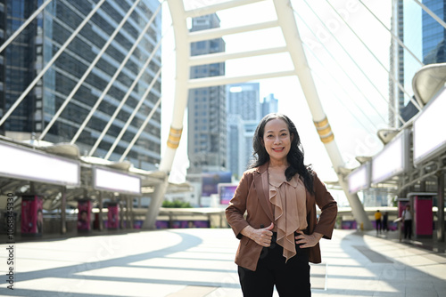 Confident mature businesswoman posing in modern cityscape