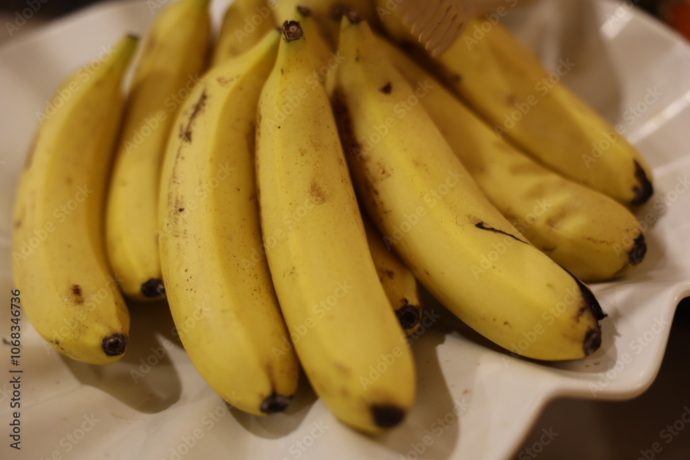 A stunning and vibrant display of fresh yellow bananas is artistically arranged upon a beautiful plate A stunning and vibrant display of fresh yellow bananas is artistically arranged upon a beautiful plate