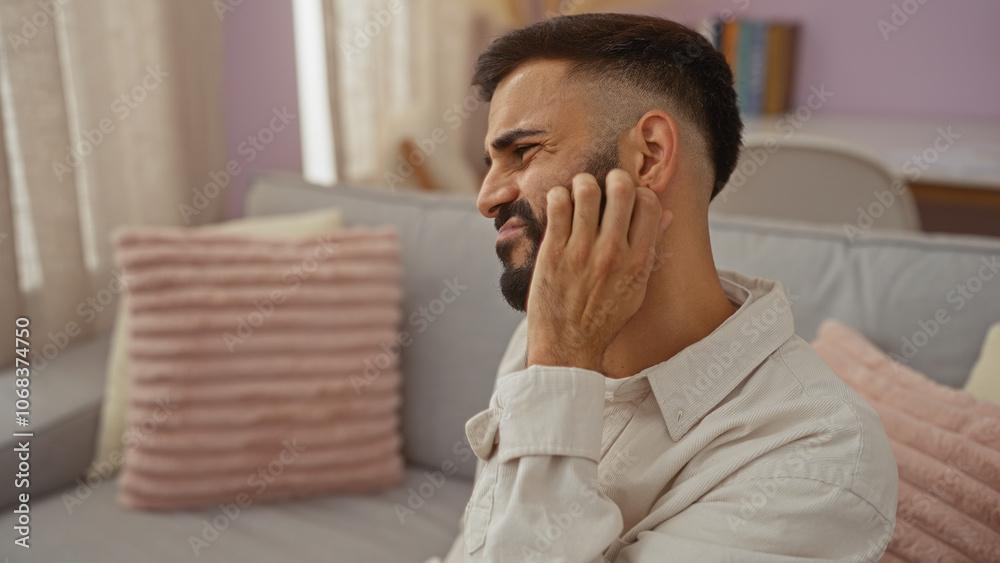 Young hispanic man with beard indoors in a living room Young hispanic man with beard indoors in a living room
