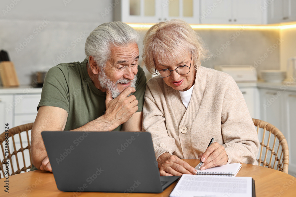 Pension savings. Senior couple planning budget at wooden table indoors Pension savings. Senior couple planning budget at wooden table indoors