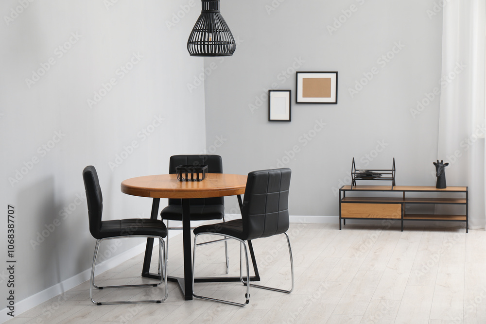 Fototapeta premium Wooden table with black chairs in stylish dining room