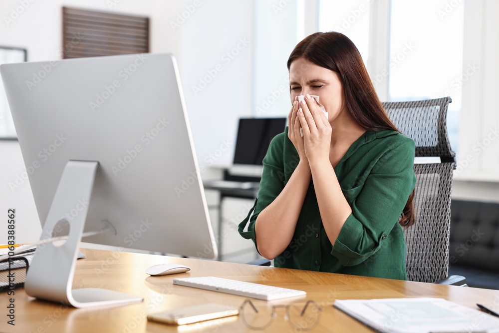 Sick woman with runny nose at table in office Sick woman with runny nose at table in office