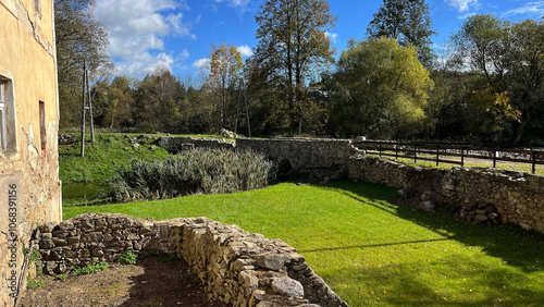 Ancient courtyard of an old castle with a half-ruined wall and a bridge with green grass. Poland, Jelenia Gora photo