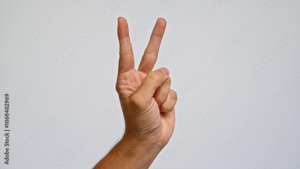 Man hand making victory gesture on plain white background showing peace sign Man hand making victory gesture on plain white background showing peace sign
