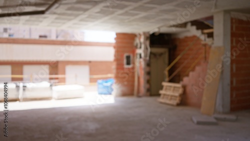 Blurred view of an unfinished construction site with defocused bricks, scaffolding, and materials in the background, giving a sense of incompletion and ongoing building work photo