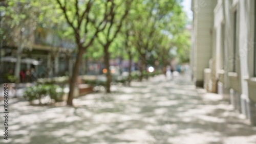 Blurry outdoor street scene with blurred trees and defocused background in park with natural lighting during daytime reflecting a serene and peaceful urban environment