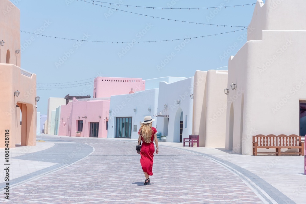 Female tourist walking on the Colorful Streets in Mina District Corniche, Doha Marina, Doha, Qatar