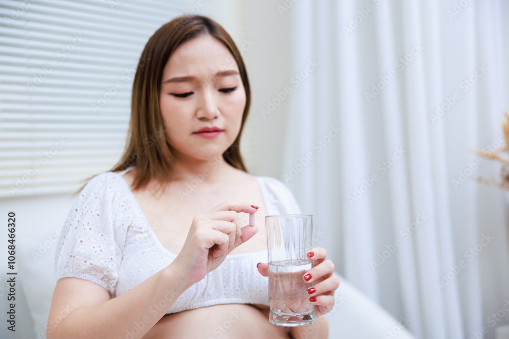 pregnant young asian woman tired of drug capsules. pregnant young asian woman tired of drug capsules.