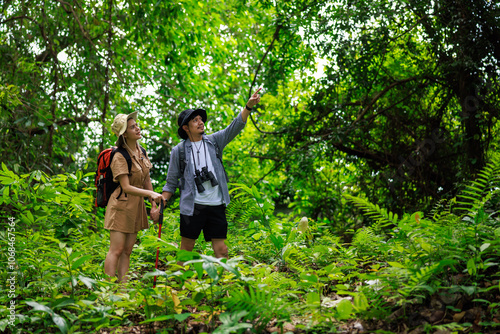 young asian couple backpacker travel in forest wild together. Attractive man and woman traveler walking and exploring nature wood with happiness and fun during holiday vacation trip