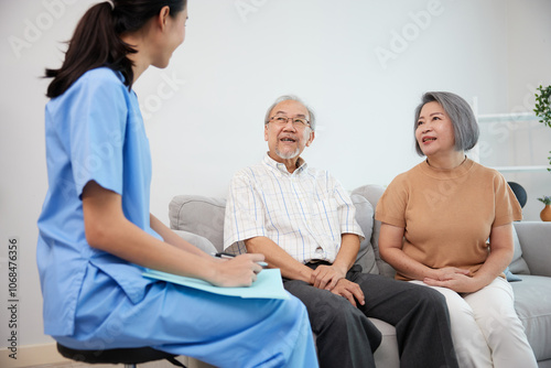 nurse or caregiver meeting and talking with about health with senior couple